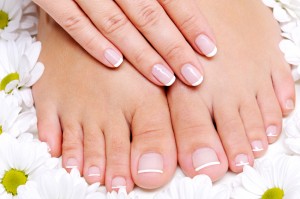 Beauty treatment of a  female feet with camomile's flower around it